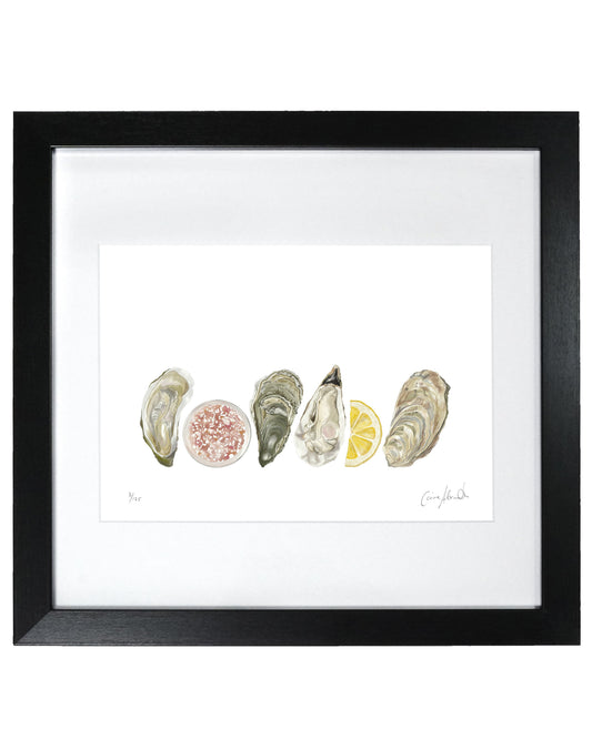 Framed artwork of oyster shells and a lemon slice on a white background