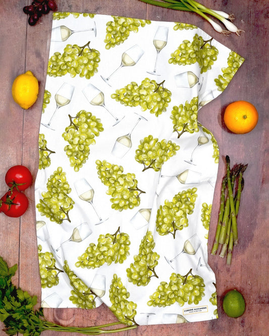 Tea towel featuring illustrations of white wine glasses and grapes